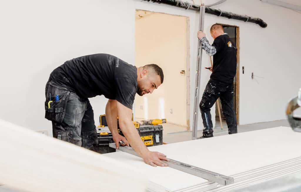 Tømrer fra AQ Entreprise der måler materialer op